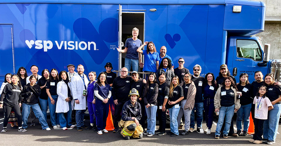 VSP Eyes of Hope and Power of Sight team members stand with Los Angeles-area optometrists and firefighter in front of a VSP Eyes of Hope mobile clinic at a relief vision care clinic following the 2025 Pacific Palisades wildfire.